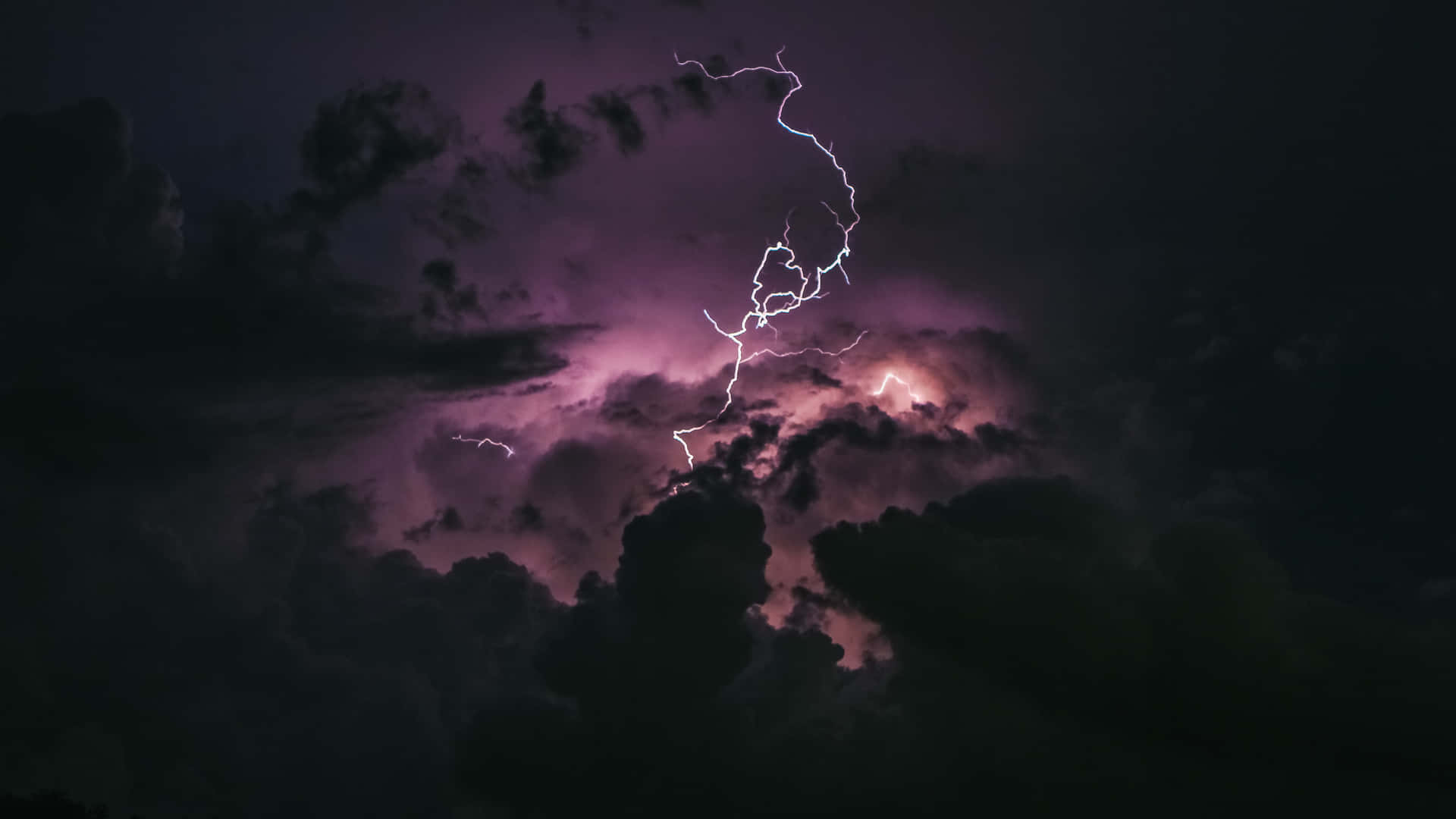 紫色閃電照亮夜晚的黑暗暴風雲。