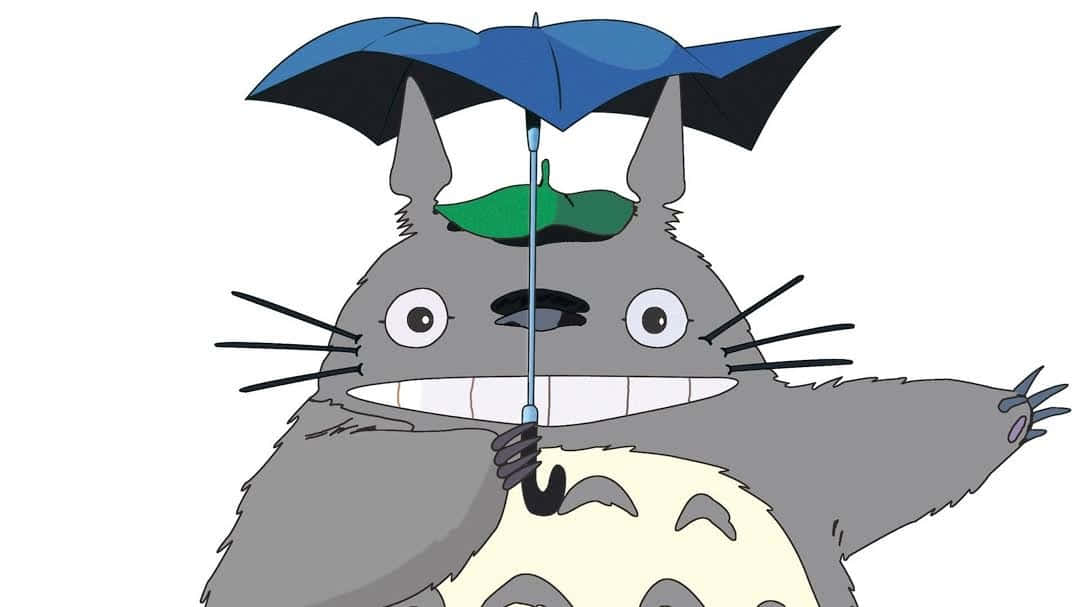 一個微笑的灰色龍貓拿著一把帶有綠色葉子的藍色雨傘。