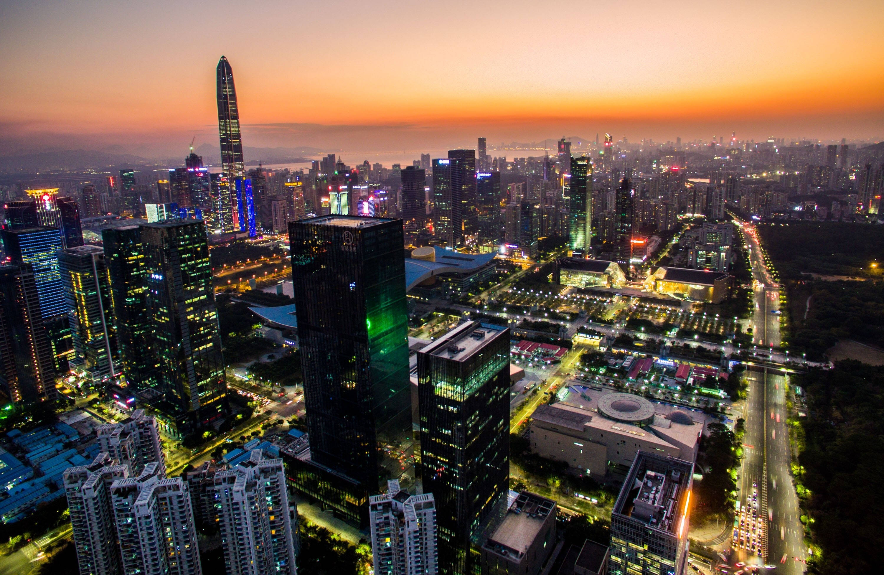 深圳城市夜景 壁紙 — 日落時分未來城市景觀的鳥瞰圖，閃爍的摩天大樓和燈火通明的街道。