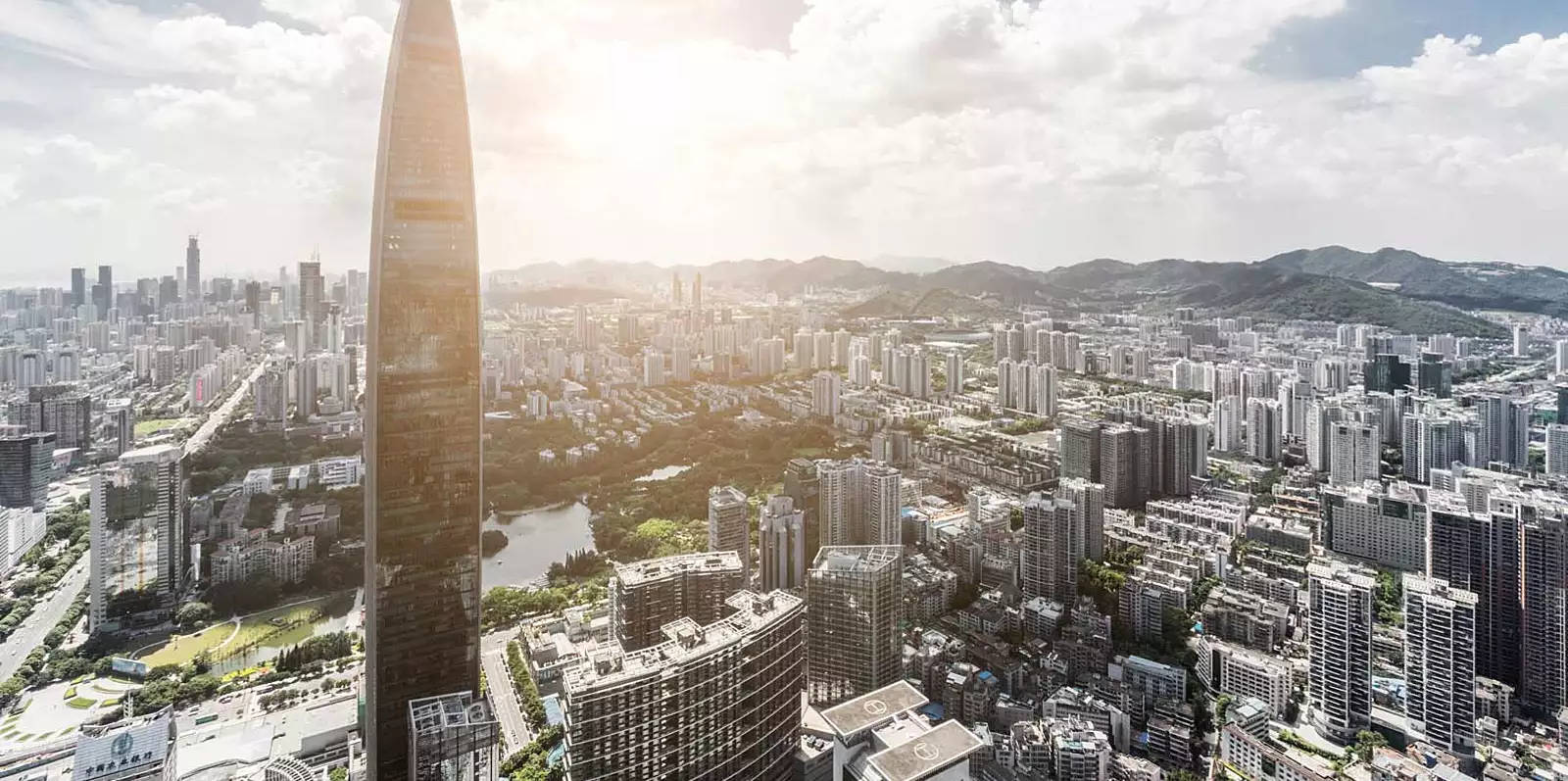 深圳城市生活 壁紙 — 現代城市景觀的鳥瞰圖，以高聳的摩天大樓為主，太陽在其後方閃耀。