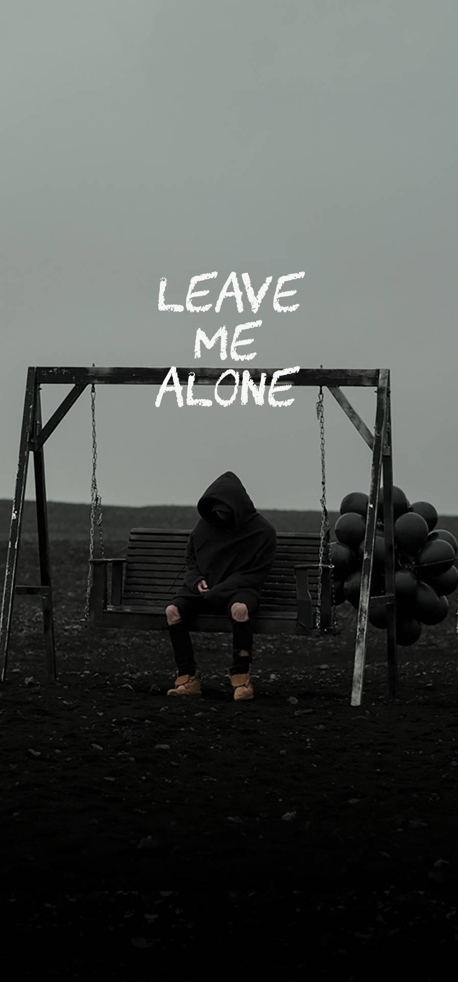 穿連帽衫的人坐在鞦韆長椅上，帶有 leave me alone 文字