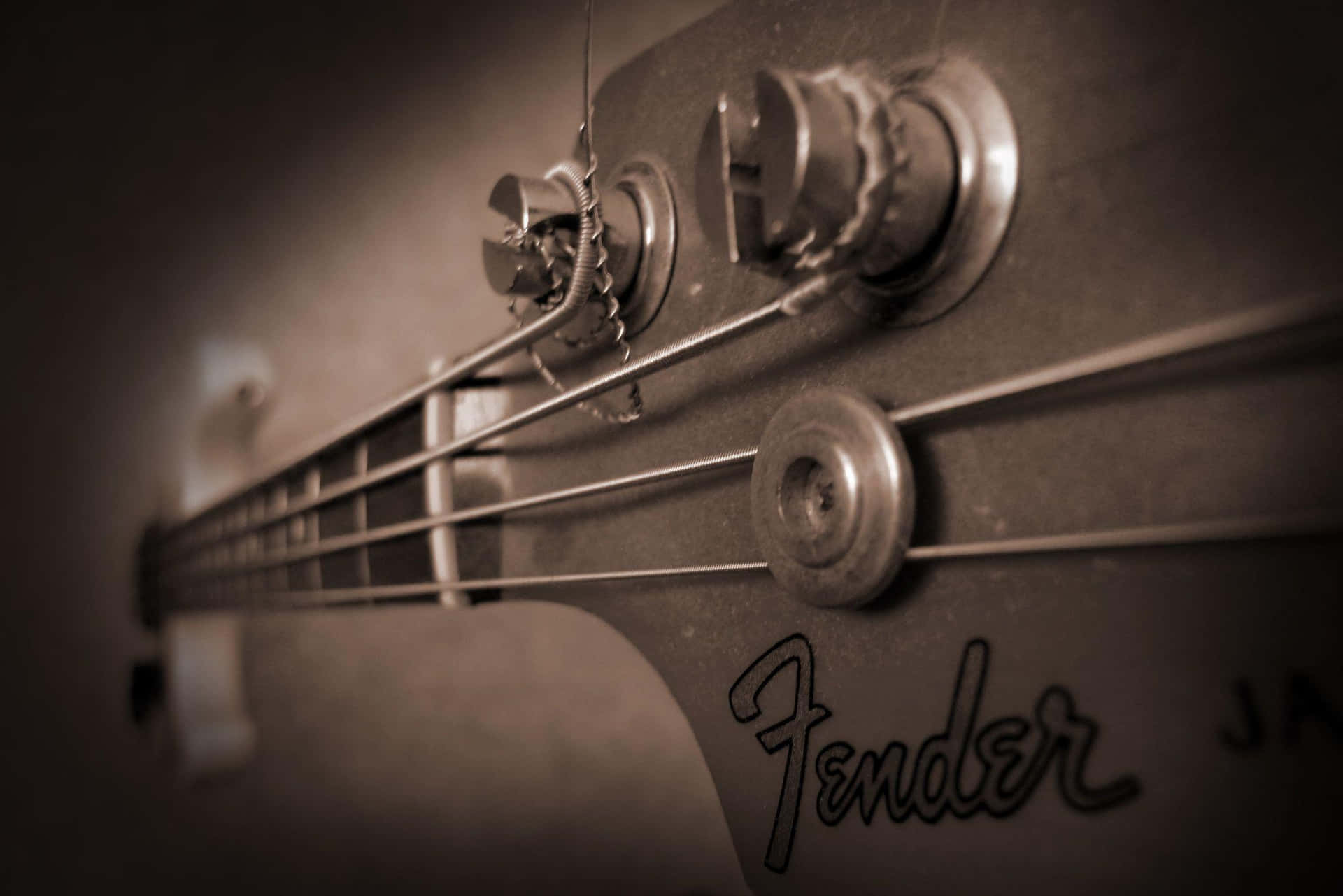 復古Fender低音結他琴頭，帶有調音旋鈕和琴弦，懷舊棕色調。
