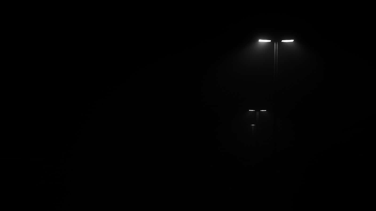 深沉單色背景 壁紙 — 兩盞鋒利嘅街燈穿透深黑嘅夜晚，喺無盡嘅黑暗中投射出微弱嘅光芒。