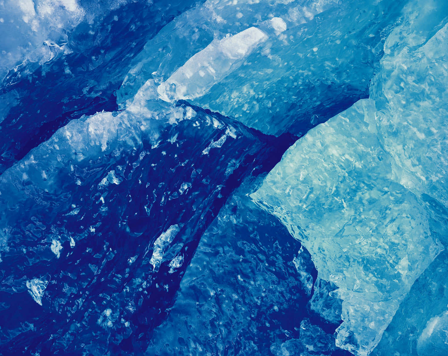 Ice Blue 桌布 壁紙 — 深淺藍色調中鋸齒狀冰層的近距離特寫，帶有半透明質感。