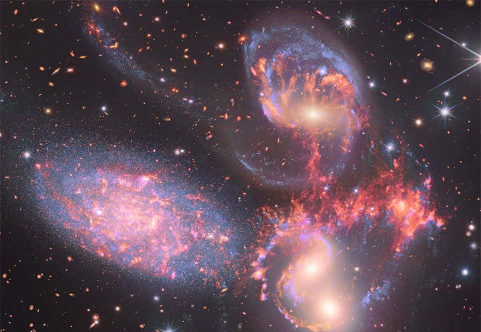 Interstellar Cloud 桌布 壁紙 — 深空中發光的星系與熾熱星雲和閃爍星星交織的充滿活力的宇宙之舞。