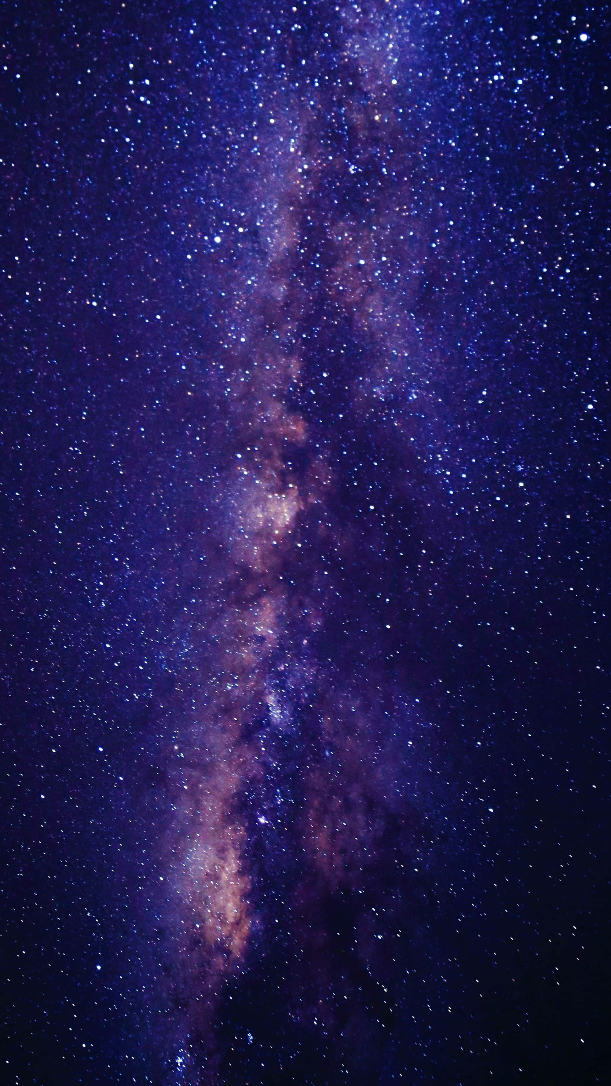 深空紫色星雲圖像 壁紙 — 令人嘆為觀止的銀河系景觀，在繁星點點的夜空映襯下散發著紫色和橙色的光芒。