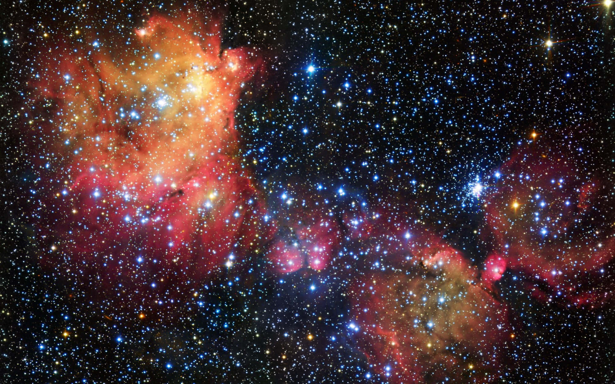深空霓虹星雲圖像 壁紙 — 充滿活力的宇宙星雲在刺眼的藍色和白色星星的星場背景下散發出火紅和橙色的光芒。