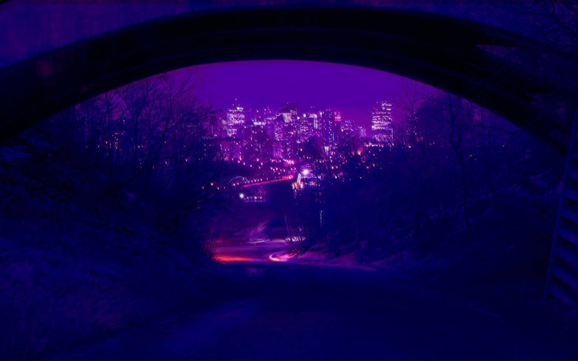 夜晚透過石拱門看到的紫色城市燈光