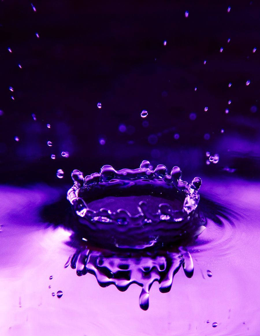 深紫色水滴靜電圖 壁紙 — 一個皇冠形狀的水滴在深色背景上濺起鮮豔的紫色液體。