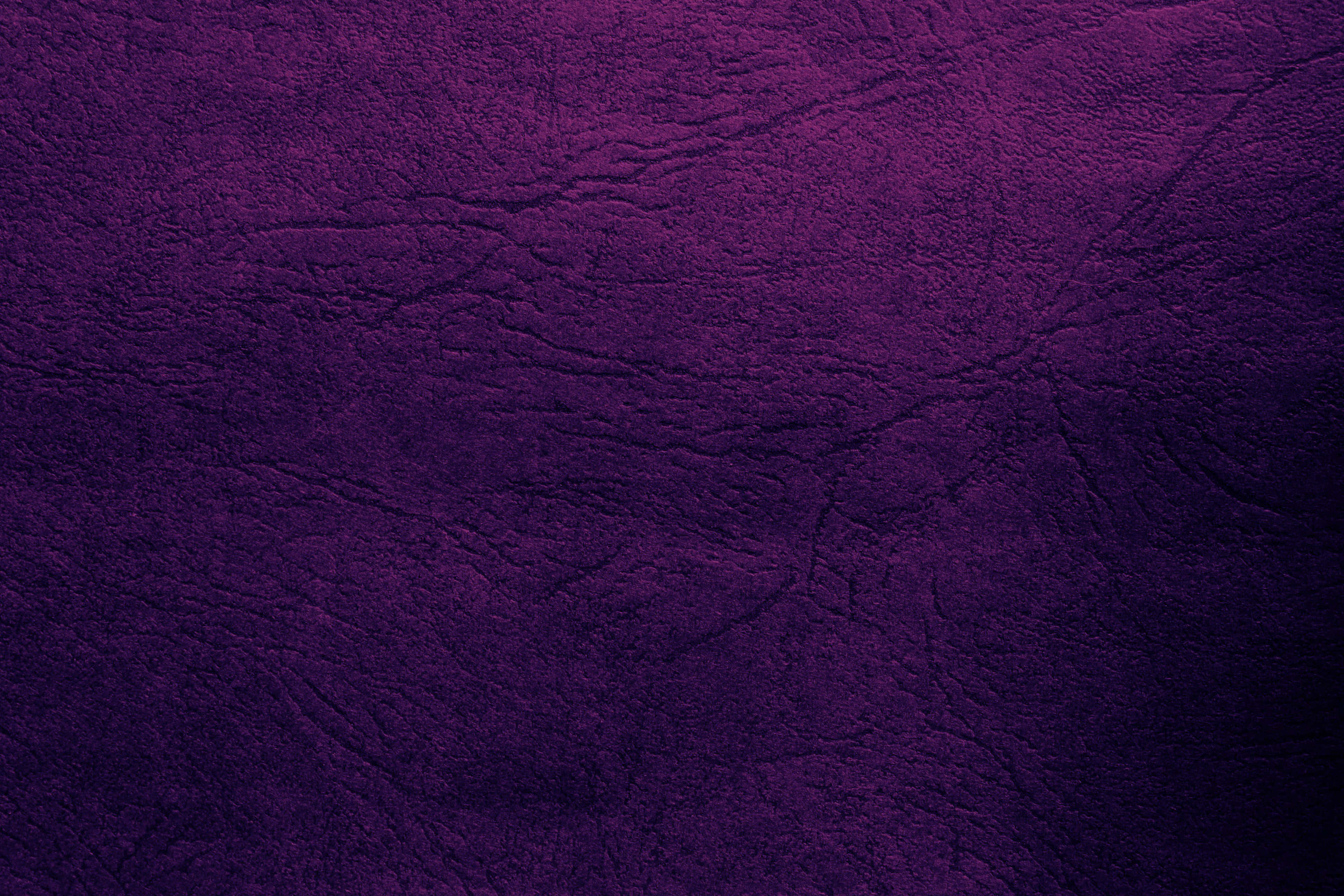 Purple Leather 桌布 壁紙 — 深紫色紋理皮革的特寫，帶有深層摺痕和微妙的漸變照明。