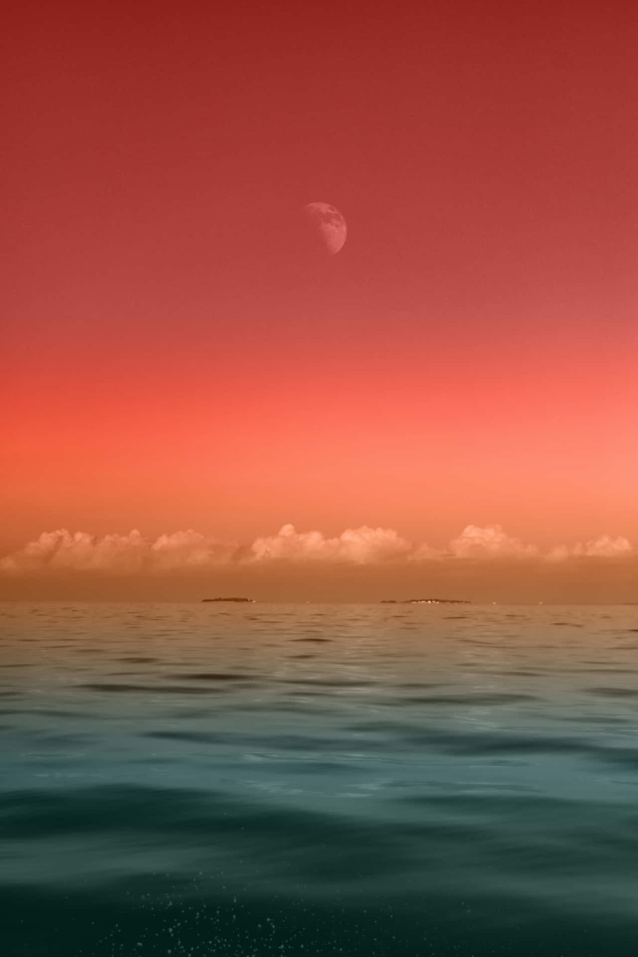 黃昏時分寧靜海洋上的新月，紅色天空和遙遠島嶼。