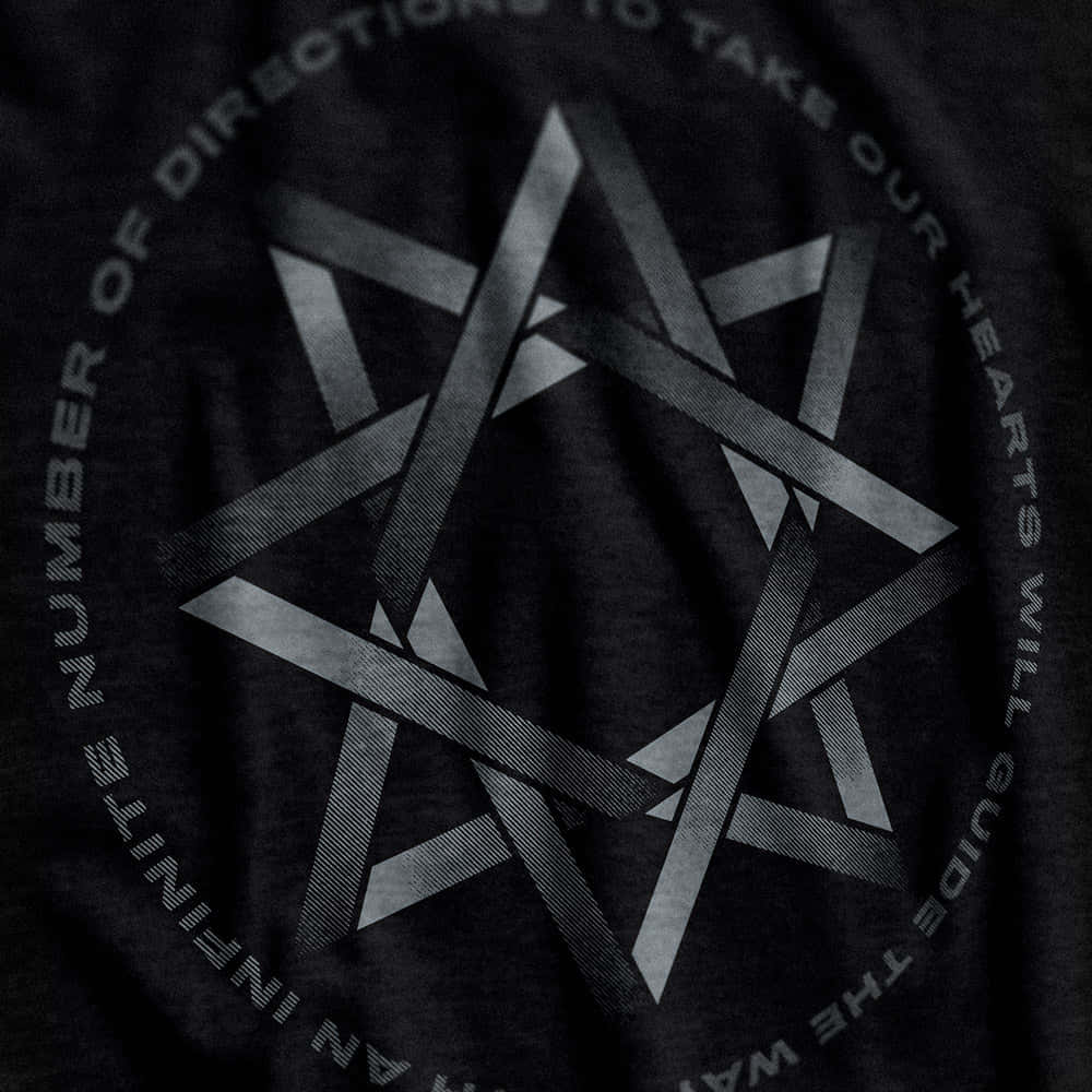 Thelema 桌布 壁紙 — 深色T恤的近距離特寫，帶有幾何星形設計和銀灰色環繞文字。