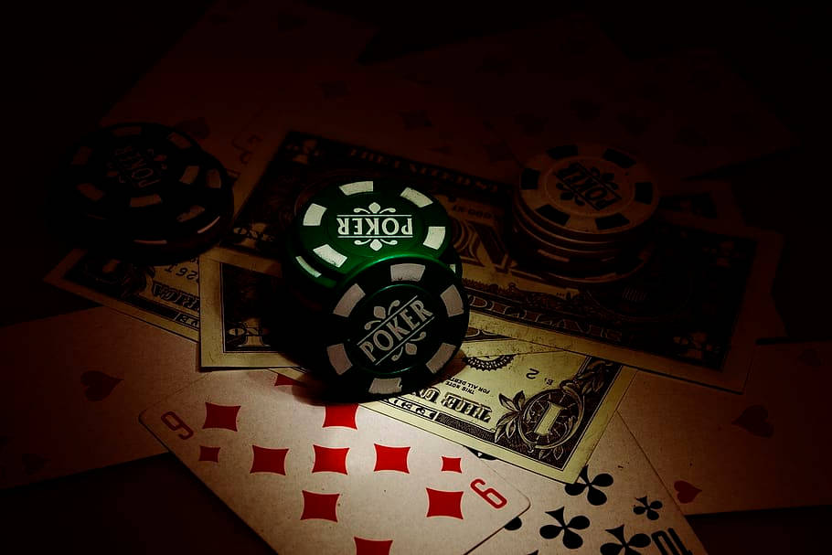 暗色桌子上的籌碼、紙牌和現金