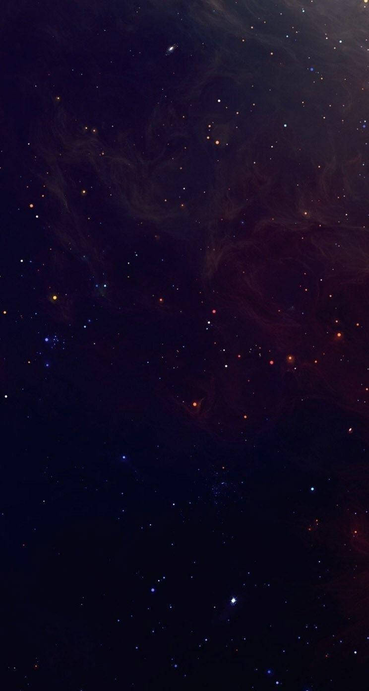深色手機紅星夜空壁紙 壁紙 — 深邃太空景觀，充滿閃爍的星星和旋轉的宇宙塵埃雲，呈現豐富的紅色和藍色。