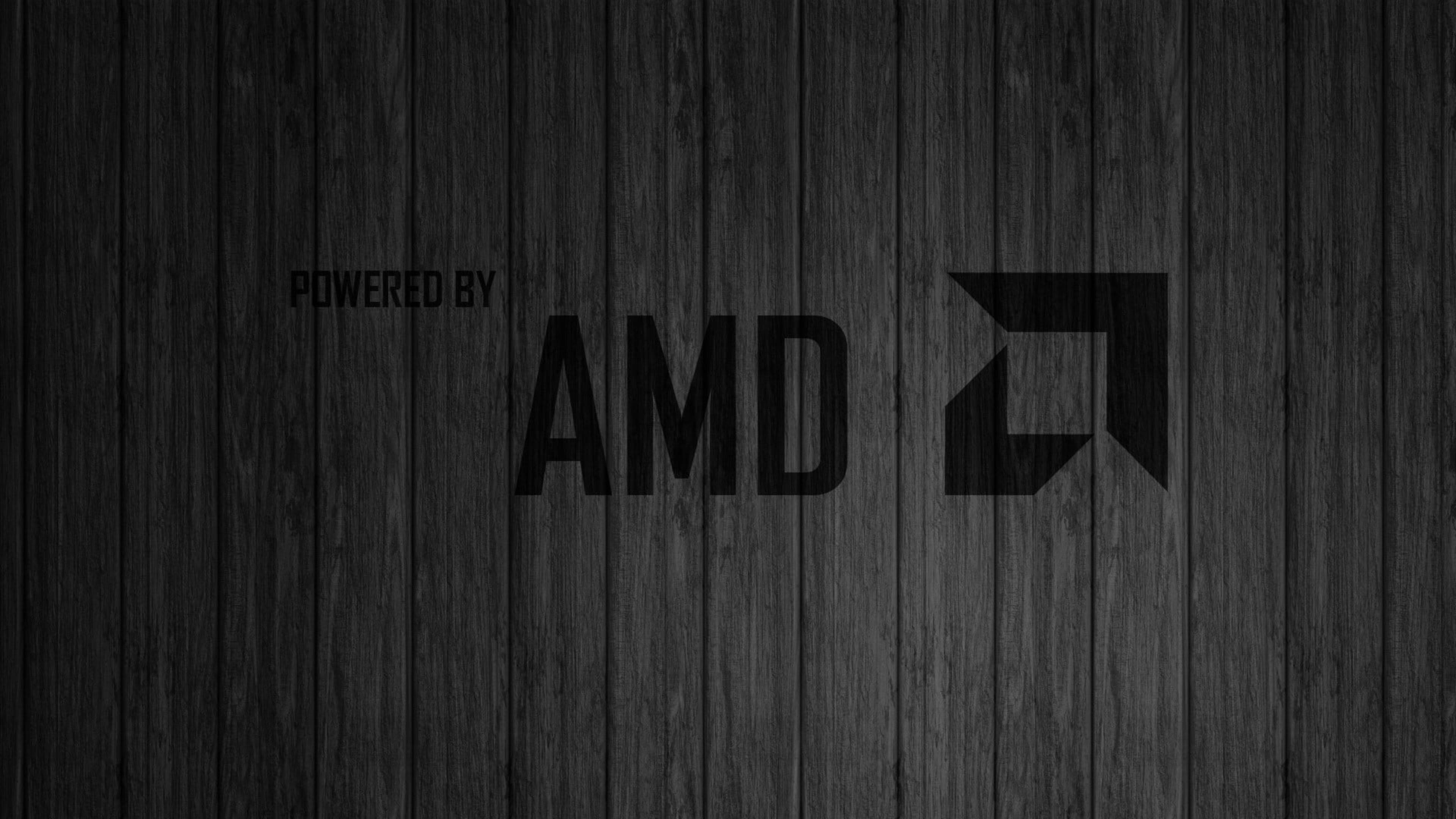 4K 桌布 壁紙 — 深色木板背景，帶有粗體黑色AMD標誌和文字powered by。