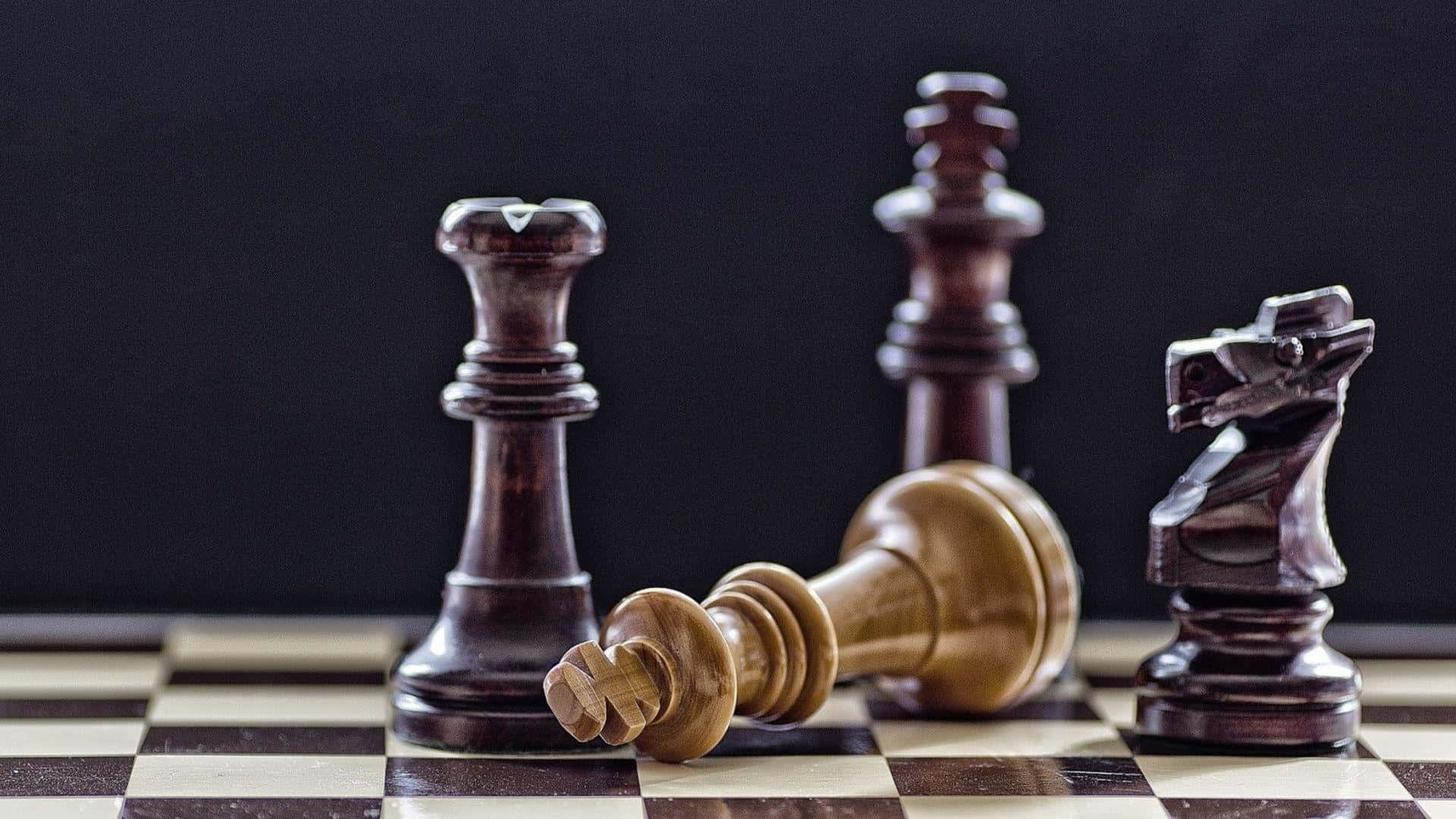 國際象棋 桌布 壁紙 — 深色木製國際象棋棋子喺黑白格仔棋盤上企立同倒下，背景係黑色。