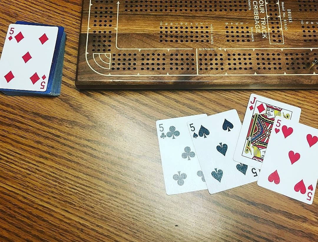 木桌上的克里比奇棋盤和撲克牌。