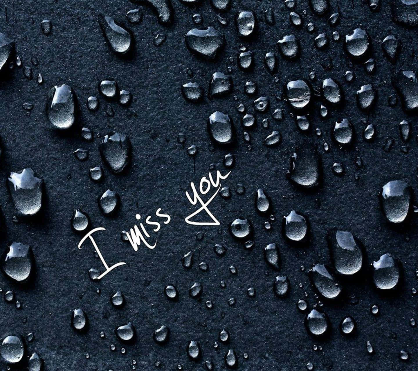 I Miss You 桌布 壁紙 — 深色紋理表面上閃爍的水滴，帶有白色手寫短語「I miss you」。