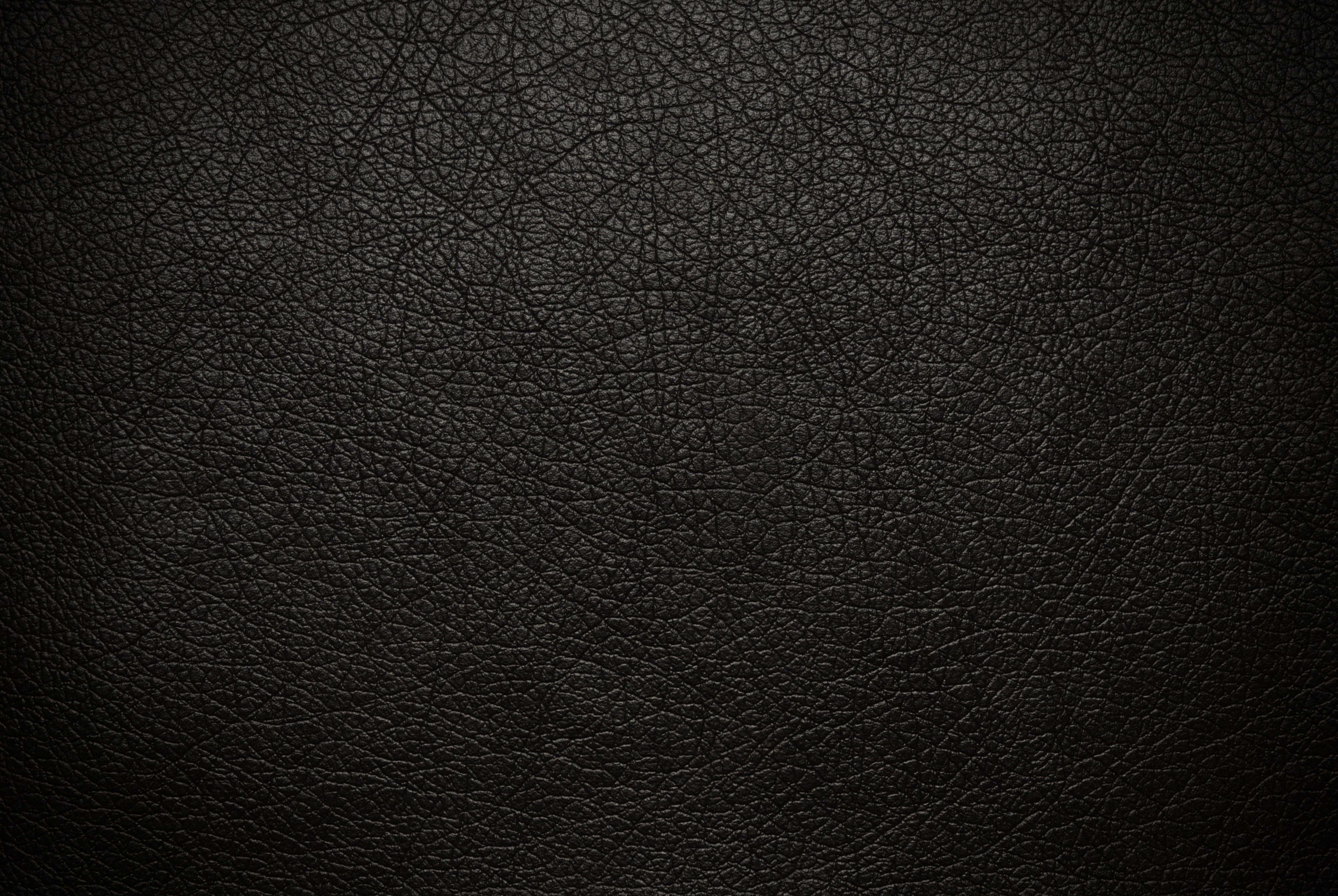texture 桌布 壁紙 — 深色紋理黑色皮革表面的特寫，帶有細微的紋理圖案和柔和的光線。