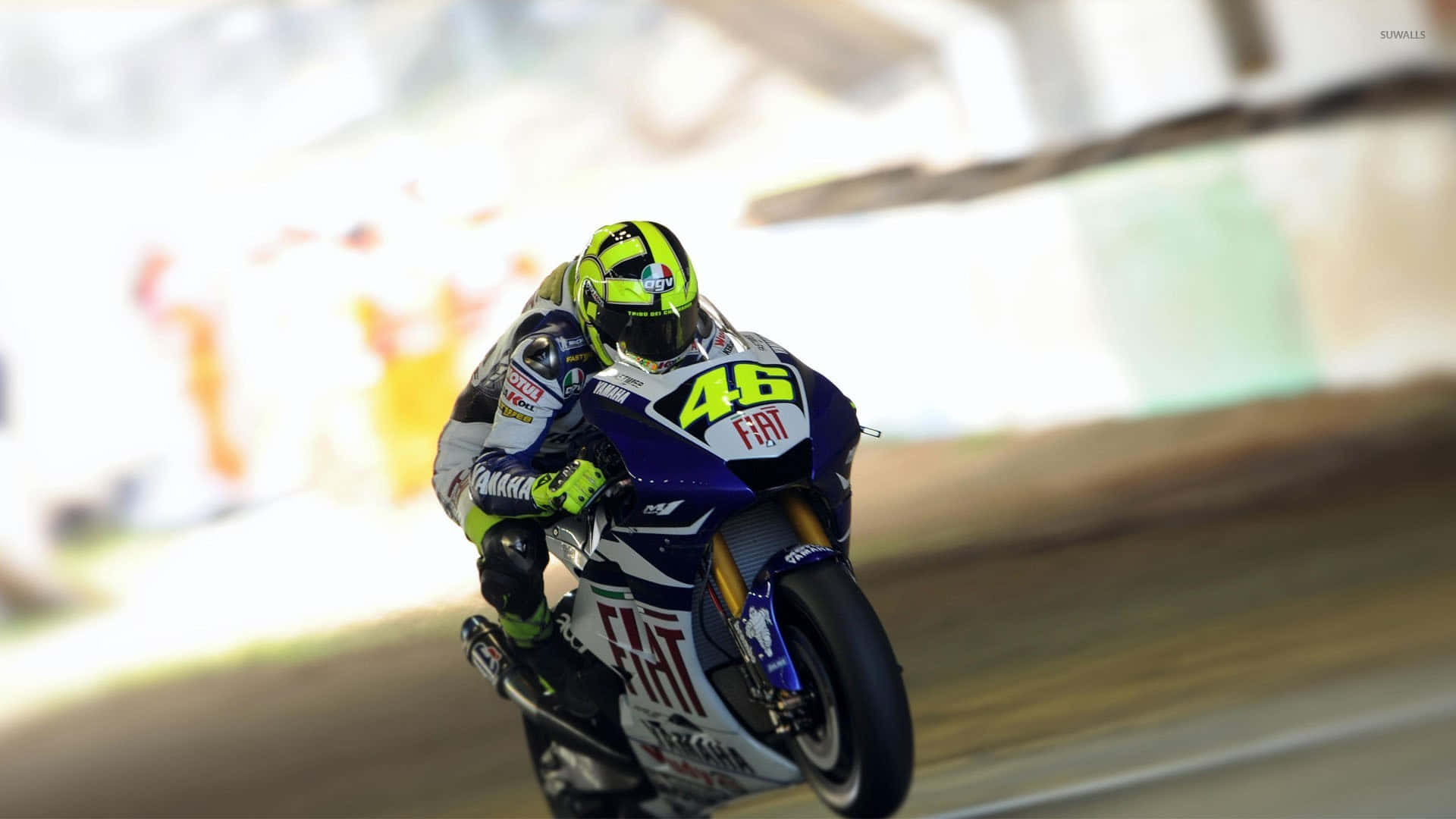 深色背景上的霓虹綠色VR46賽車號碼 壁紙 — 一位電單車賽車手在賽道上傾斜入彎，戴著亮綠色頭盔和46號賽車服。
