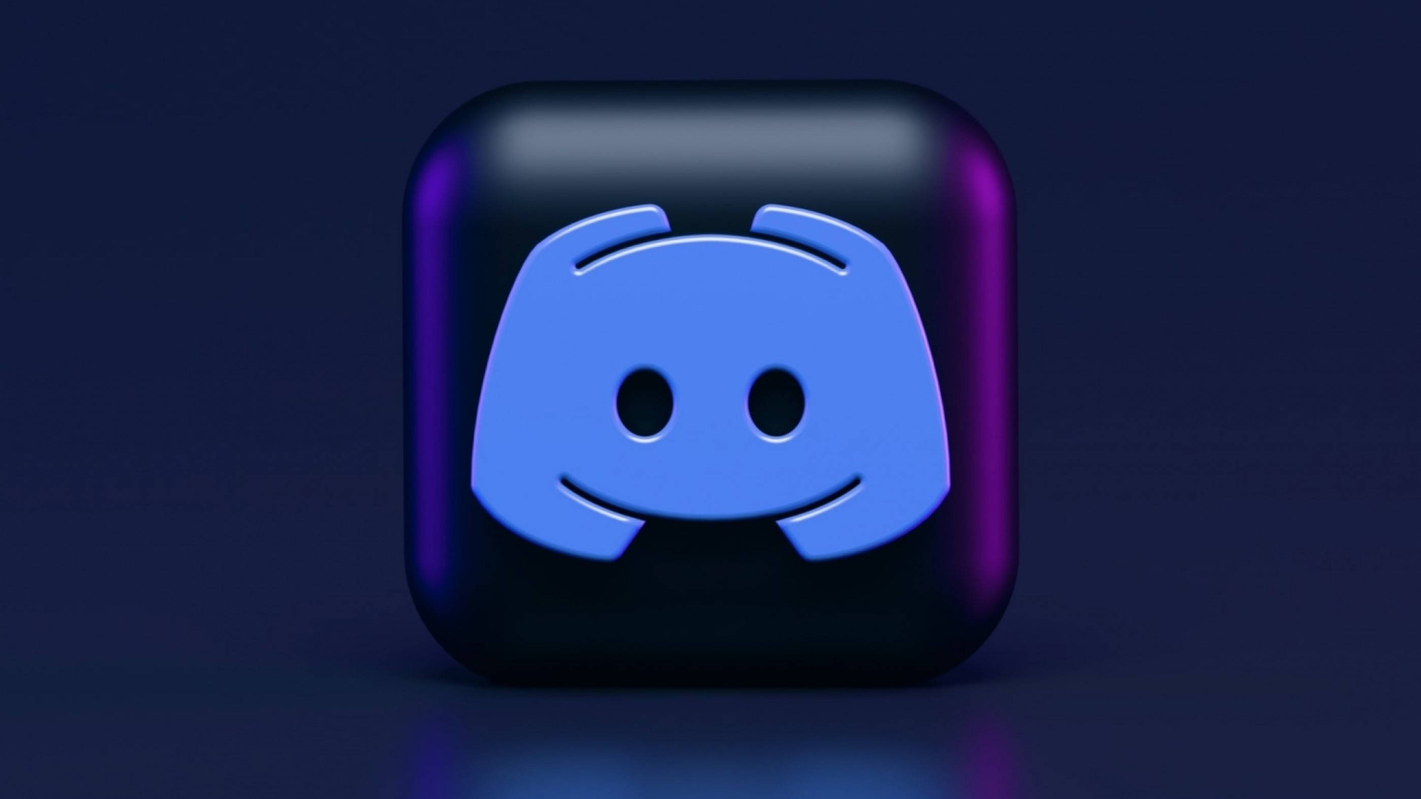 深藍 Discord 3D 立體方塊 壁紙 — 一個帶有藍色吉祥物在深紫色漸變背景上發光的光澤3D渲染Discord應用程式圖標。
