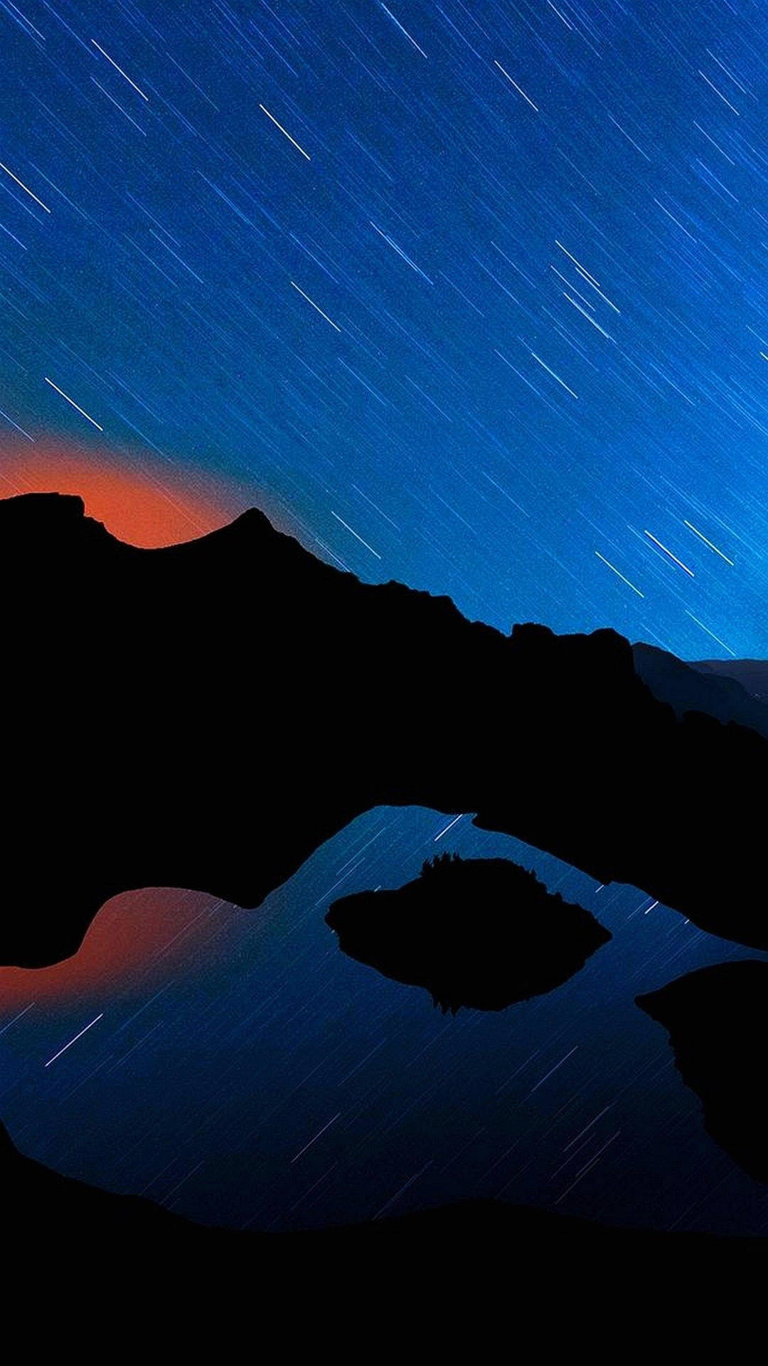 剪影般的山脈和湖泊，在星空下帶有星軌。