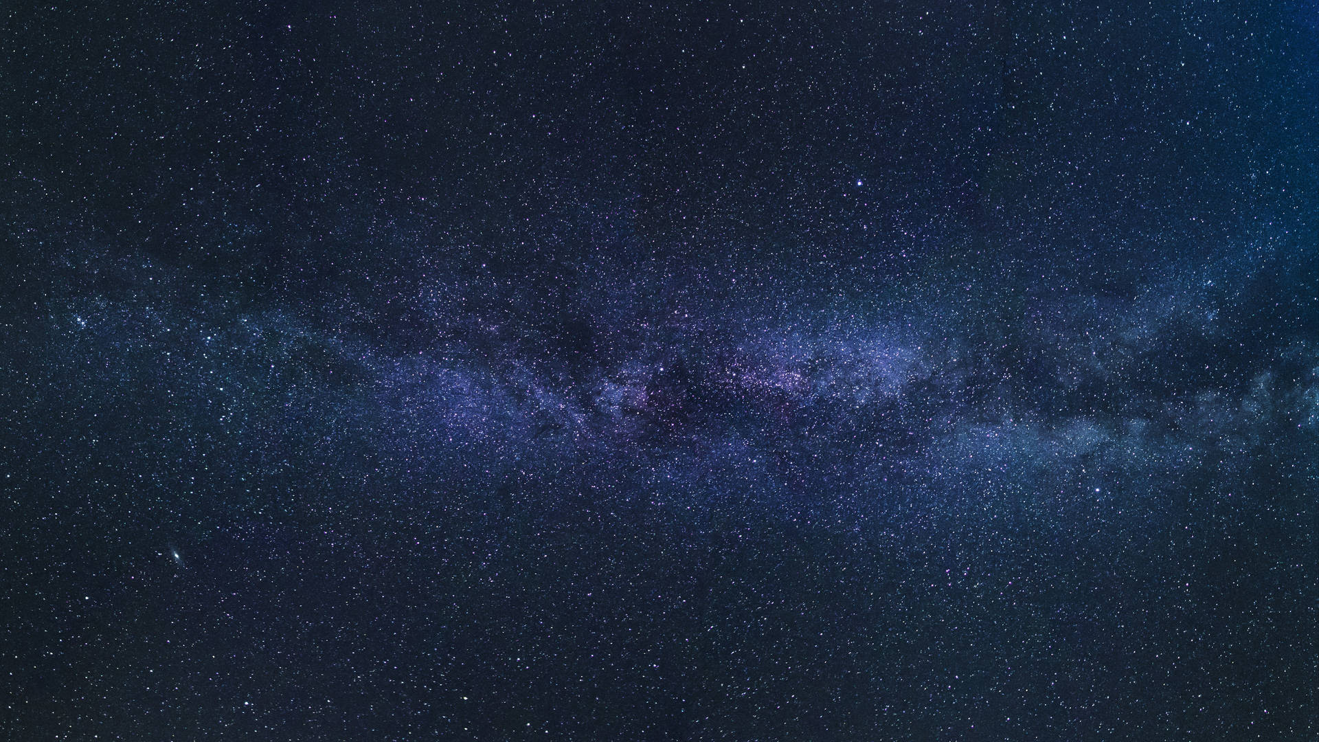 銀河系在漆黑的夜空中閃爍著紫色和藍色的星星。