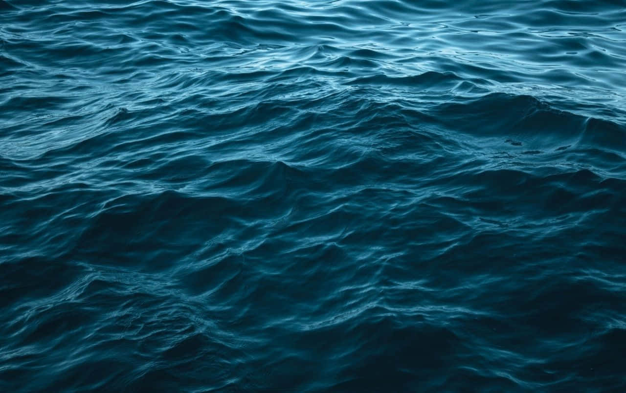 海浪 桌布 壁紙 — 深藍色海洋波浪在柔和環境光下帶有紋理運動的漣漪。