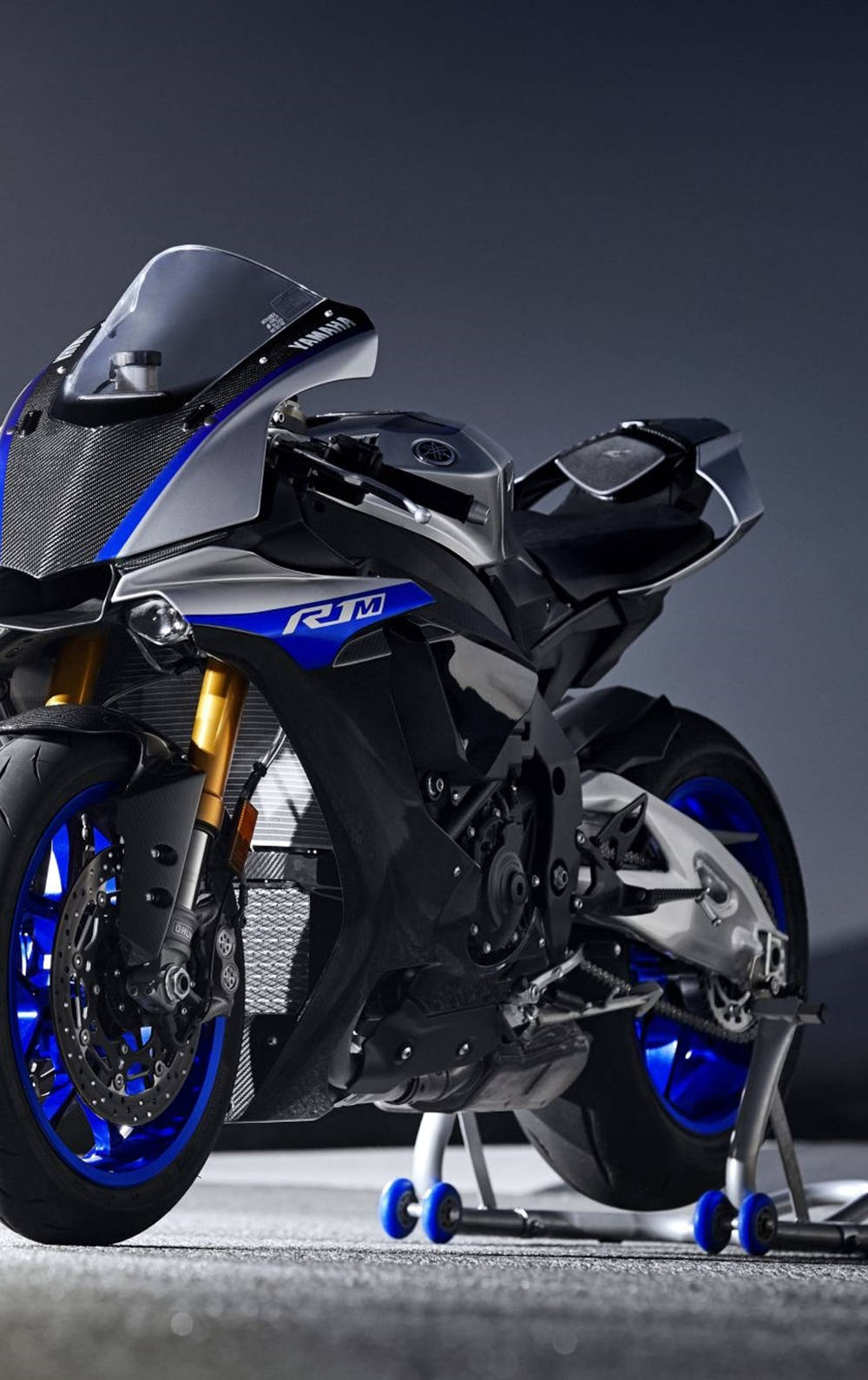 時尚的Yamaha R1M電單車，帶有藍色和金色點綴，置於工作室支架上。