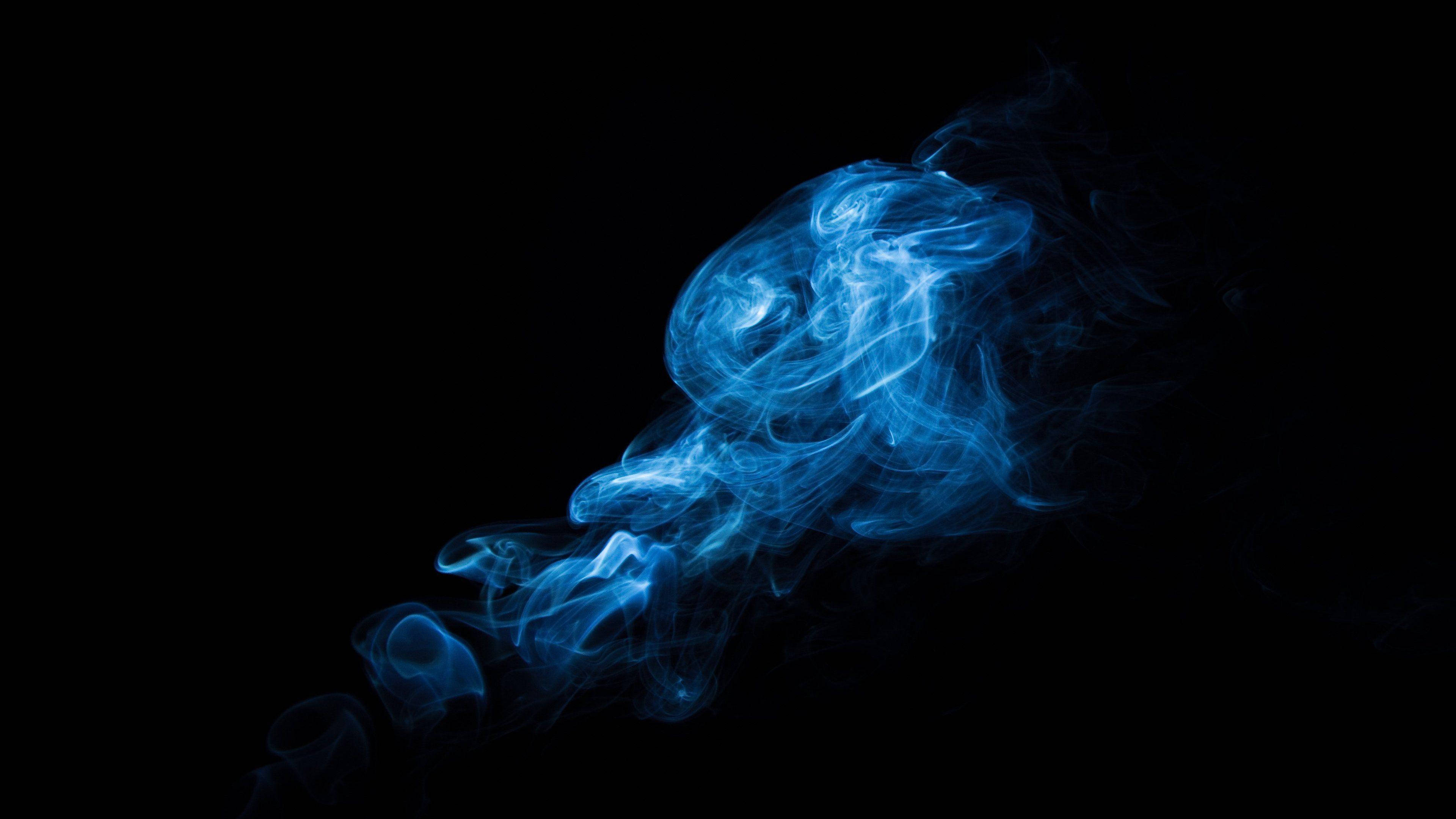 深藍調煙霧 壁紙 — 旋轉的藍色煙霧在純黑背景上發光，營造出空靈神秘的視覺效果。