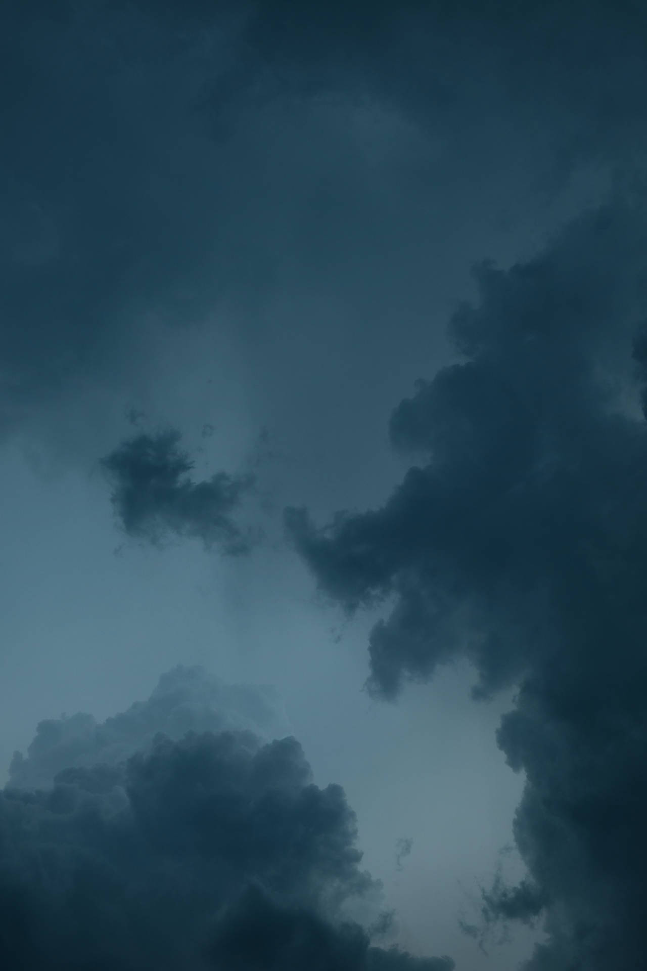 在充滿氛圍的暮色天空中旋轉的深色暴風雲。