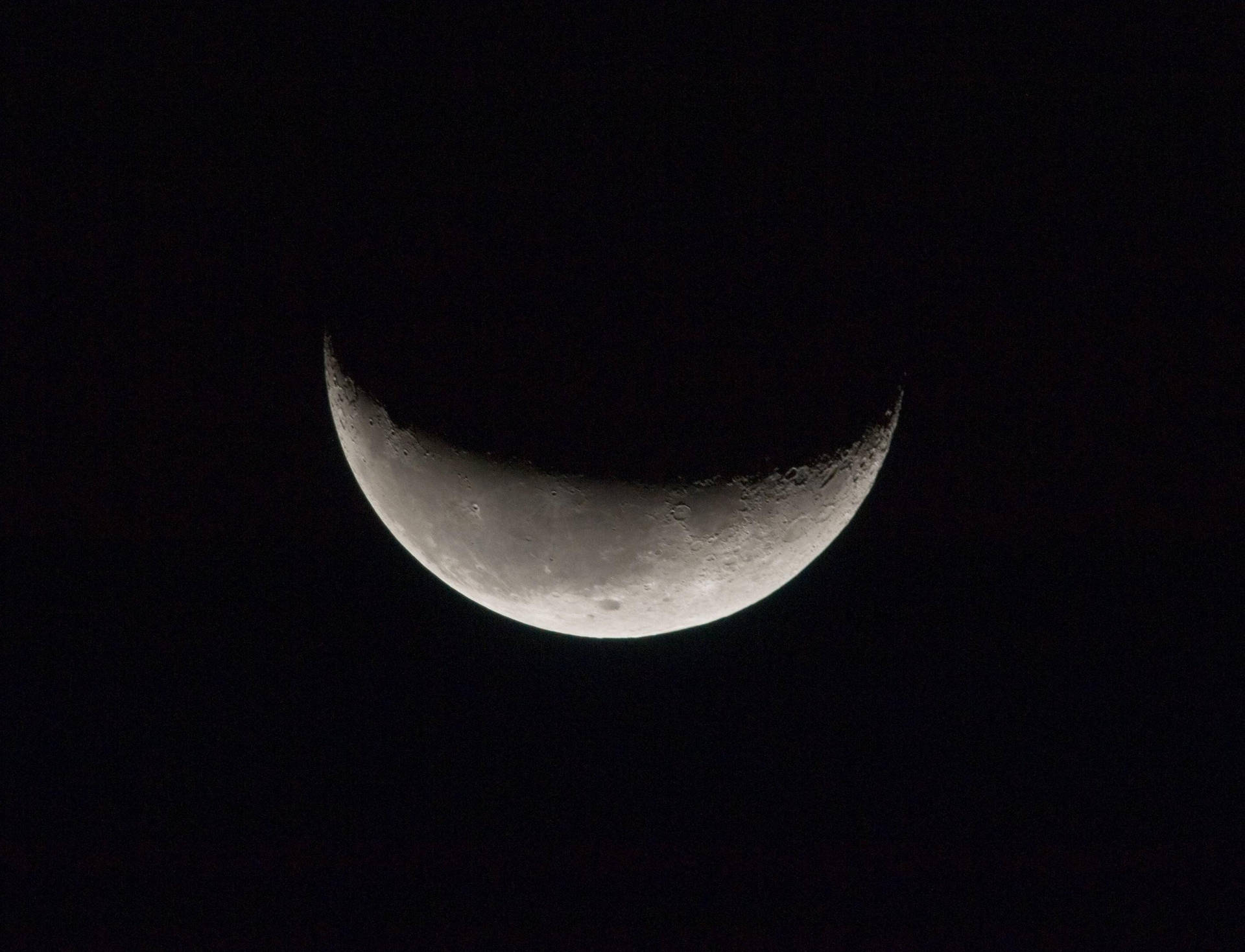 近距離拍攝的暗月彎月，顯示其環形山。太空中的衛星。