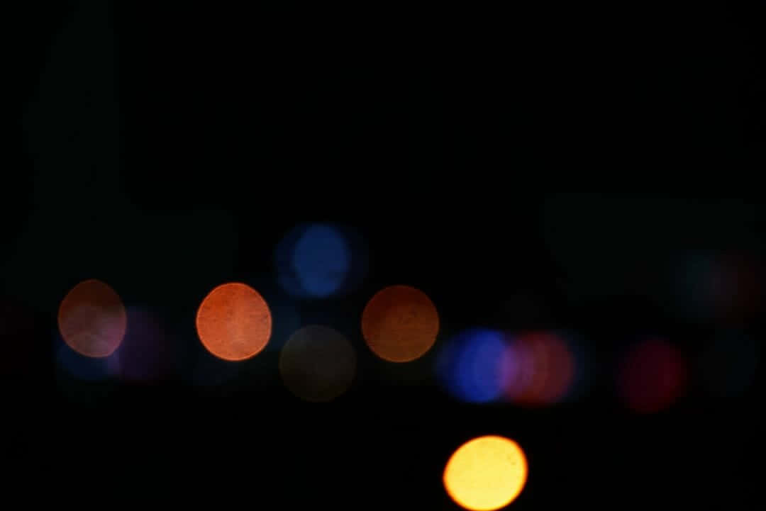 在黑暗的夜晚背景下模糊的彩色燈光