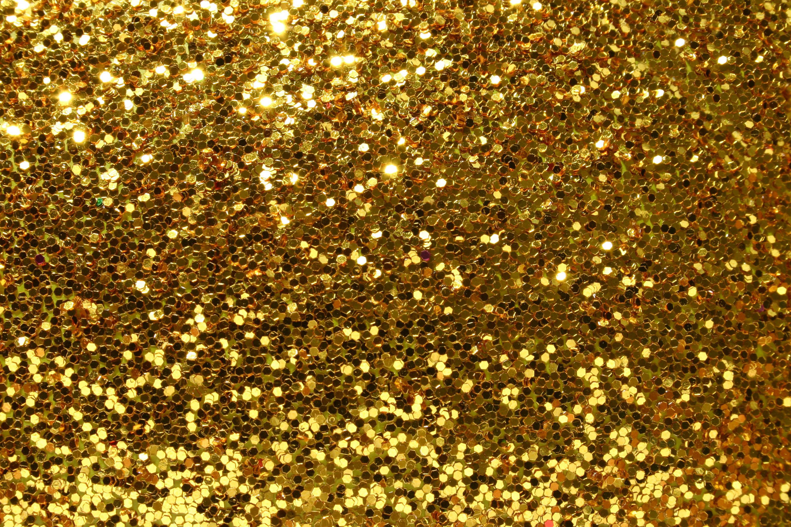 深邃閃耀金箔 壁紙 — 密集的金色閃粉顆粒在紋理閃爍的表面上捕捉明亮光線。