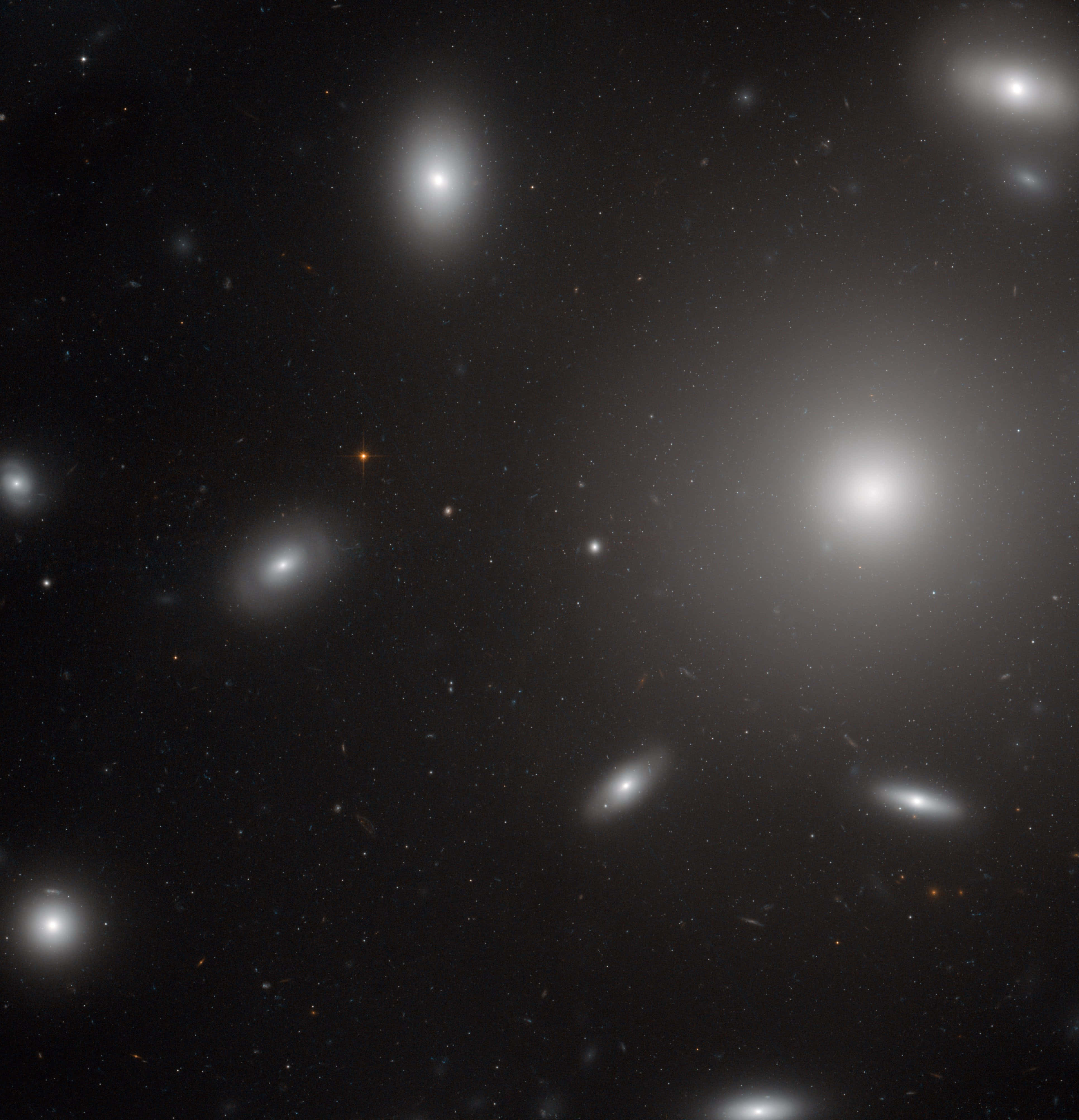 Elliptical Galaxy 桌布 壁紙 — 深邃黑色虛空中，閃爍星系與散落星體的宇宙景觀。
