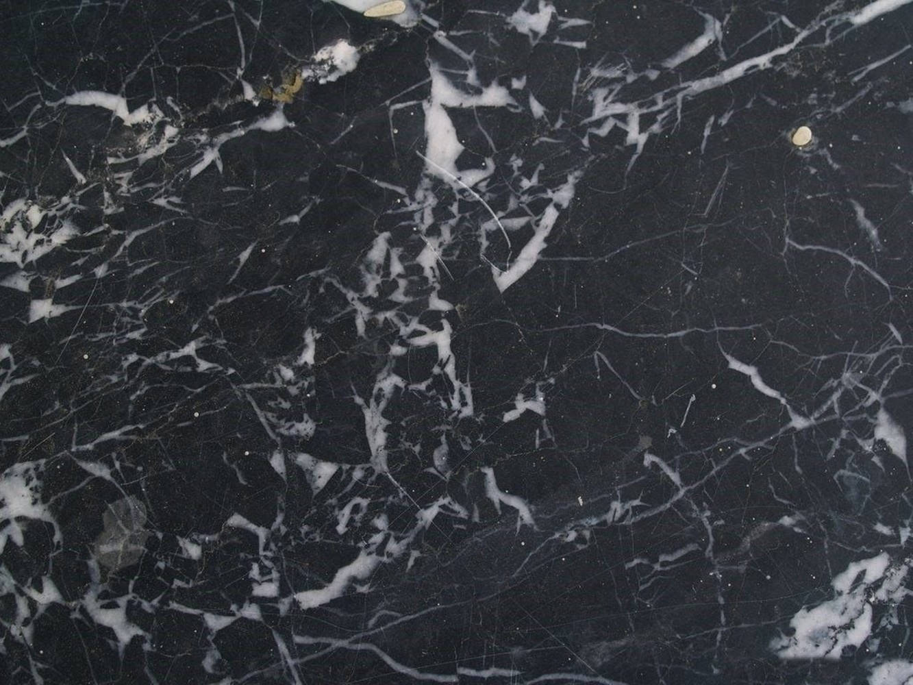 Marble Desktop 桌布 壁紙 — 深黑色大理石的近距離特寫，帶有複雜的白色和灰色紋理圖案以及微妙的金色斑點。