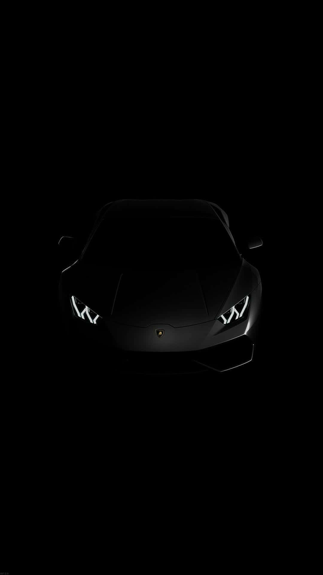 在完全黑暗中車頭燈發光的黑色林寶堅尼。