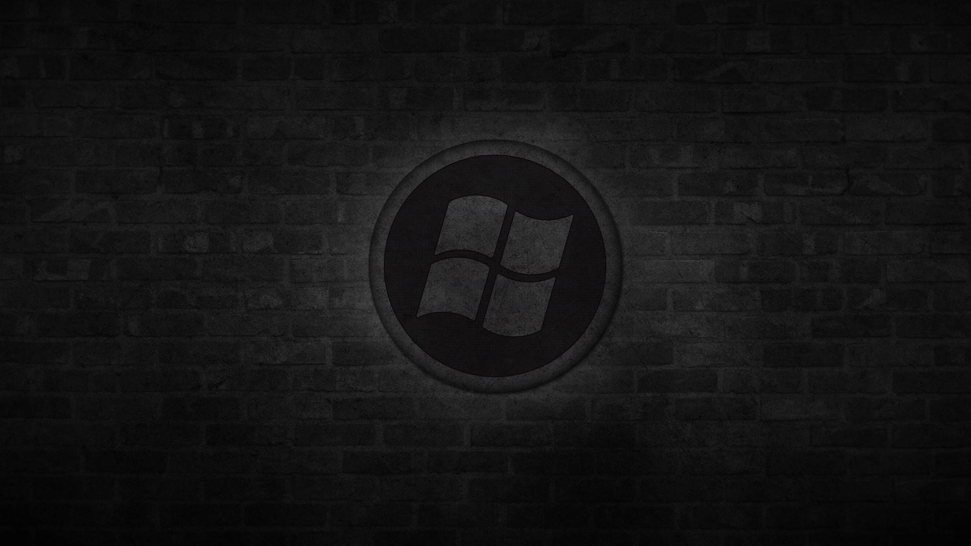 深色磚牆上聚光燈下的Windows標誌