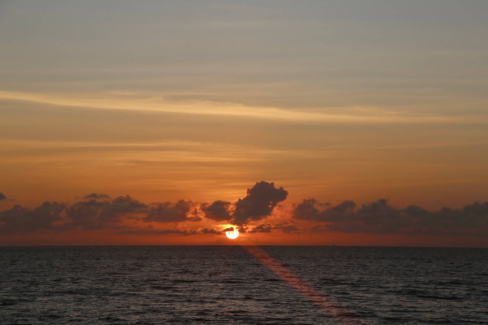 夕陽下的海洋，橙色天空與平靜水面