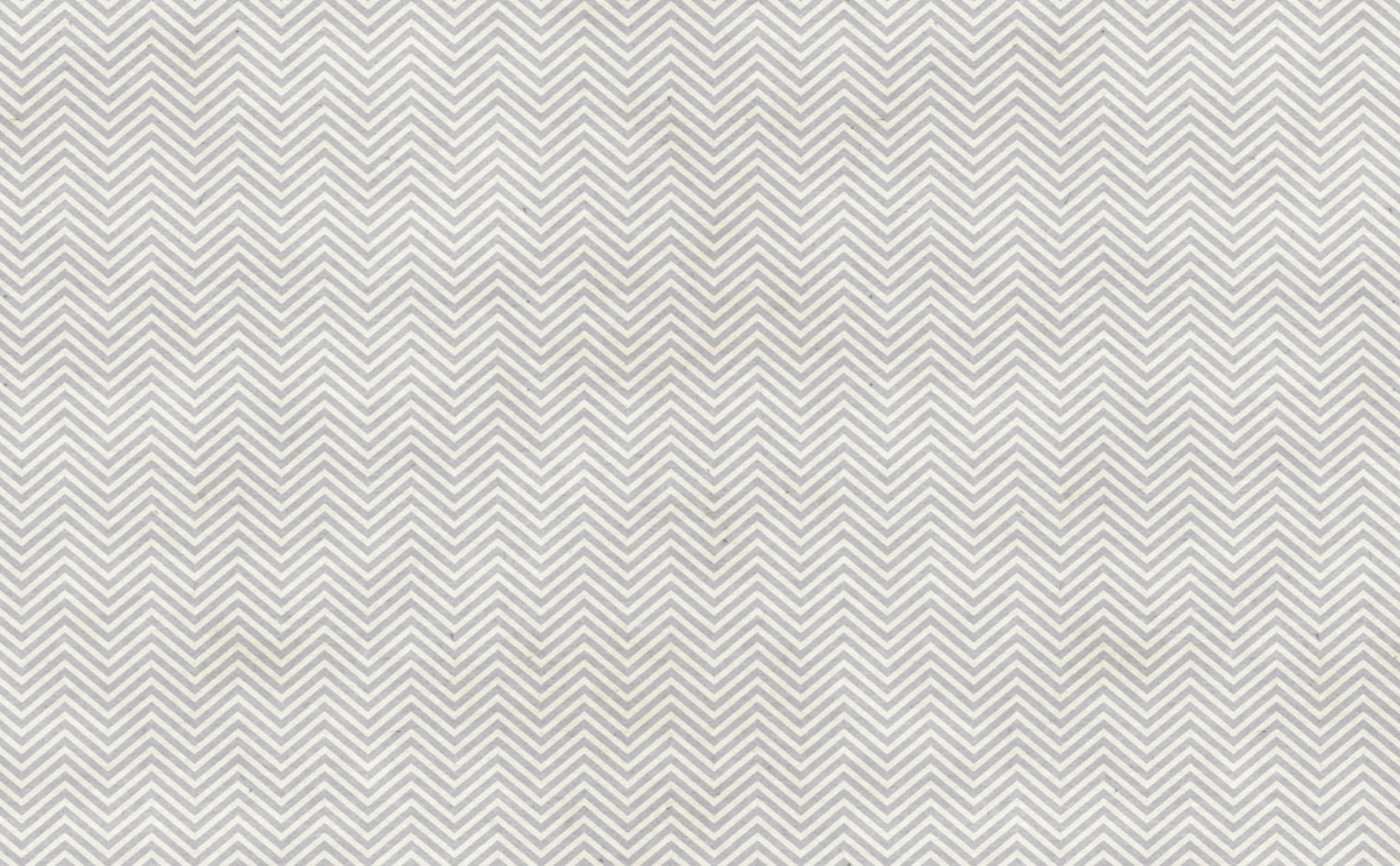 Cute Chevron 桌布 壁紙 — 淺灰色和白色人字紋圖案牆紙的特寫，帶有細微紋理。