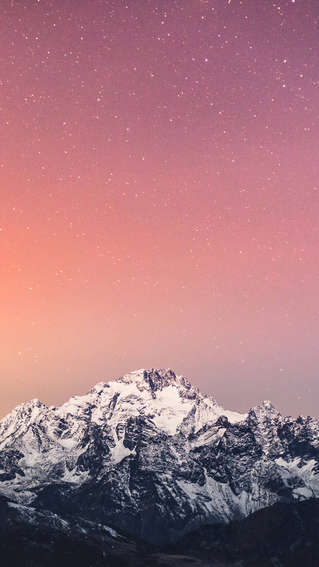 在星空粉紅色和紫色夜空下的雪山山脈。