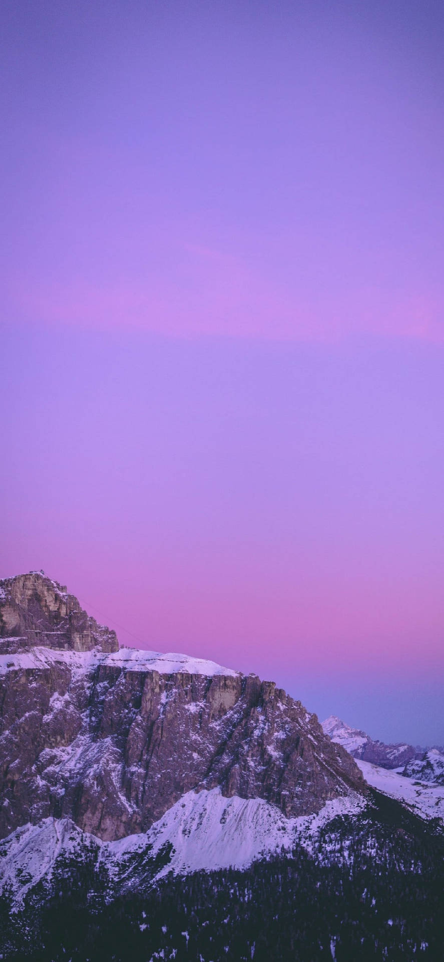 在紫色粉紅色日落天空下的雪山峰