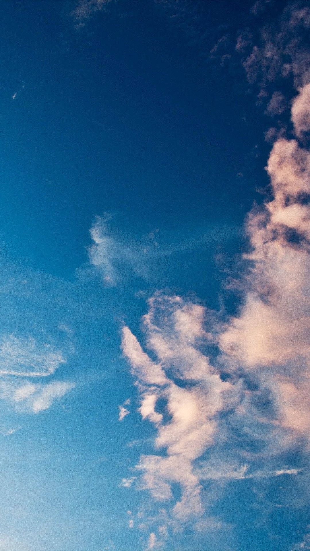淺藍色系飄逸雲朵 壁紙 — 充滿活力的藍天，帶有纖細的白雲，在地平線附近染上柔和的粉紅色調。