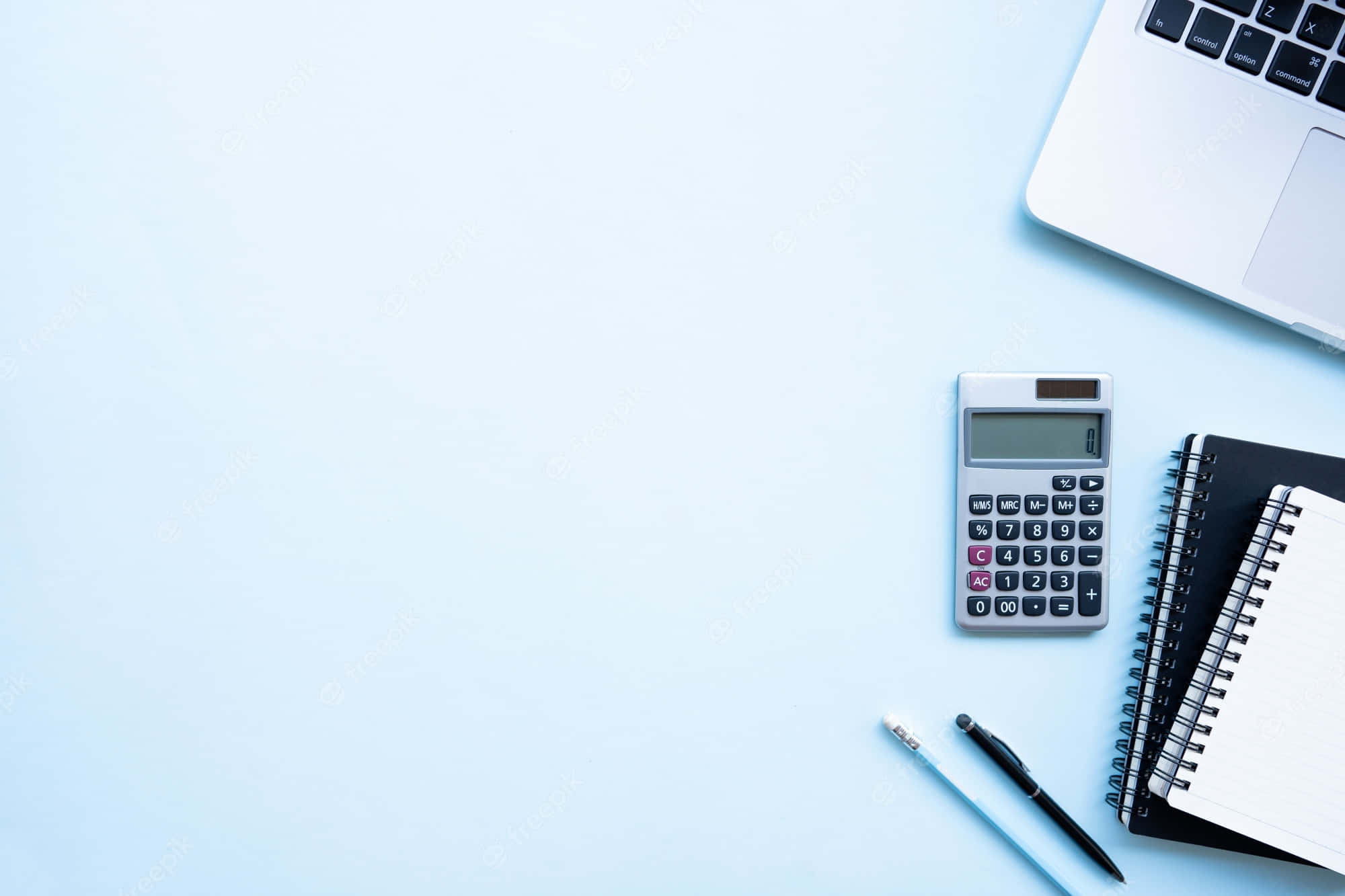 Calculator 桌布 壁紙 — 淺藍色表面上的簡約工作空間，配有手提電腦、計算機、筆記本和筆。