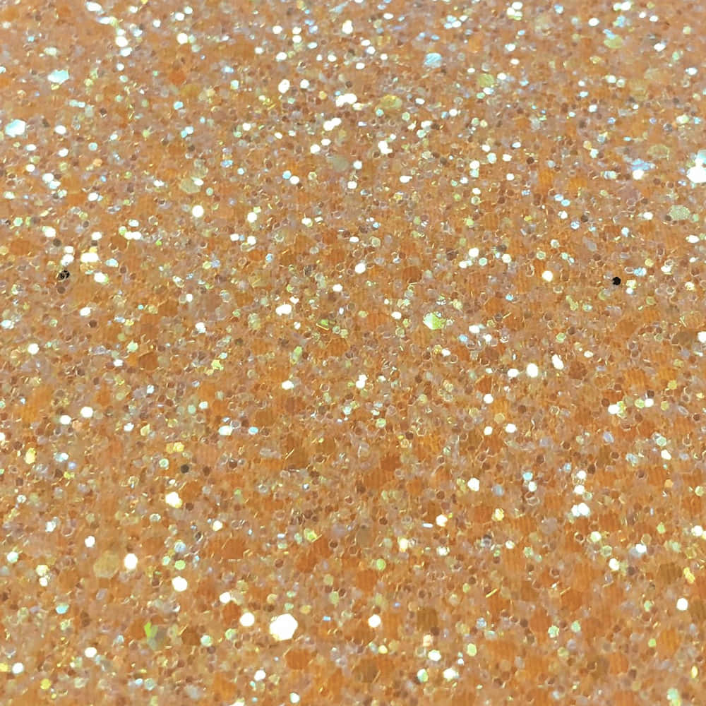 橙色紋理表面上的金色和銀色閃粉特寫。