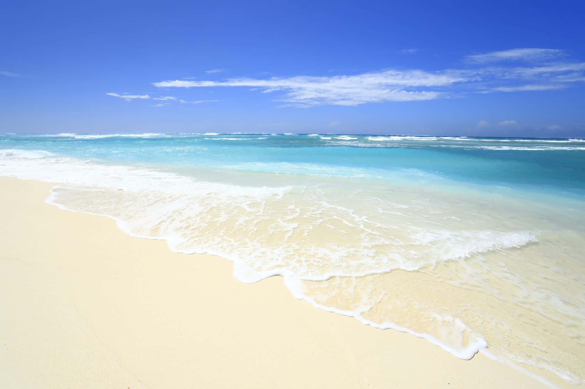 Beautiful Beach 桌布 壁紙 — 清澈的碧綠海浪輕輕拍打著純淨的白色沙灘，天空湛藍，飄著縷縷白雲。