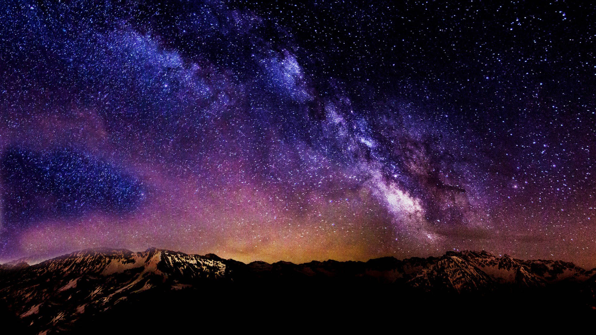 清澈美麗的天空 壁紙 — 在繁星點點的夜空下，銀河系橫跨積雪山峰的壯麗景色。