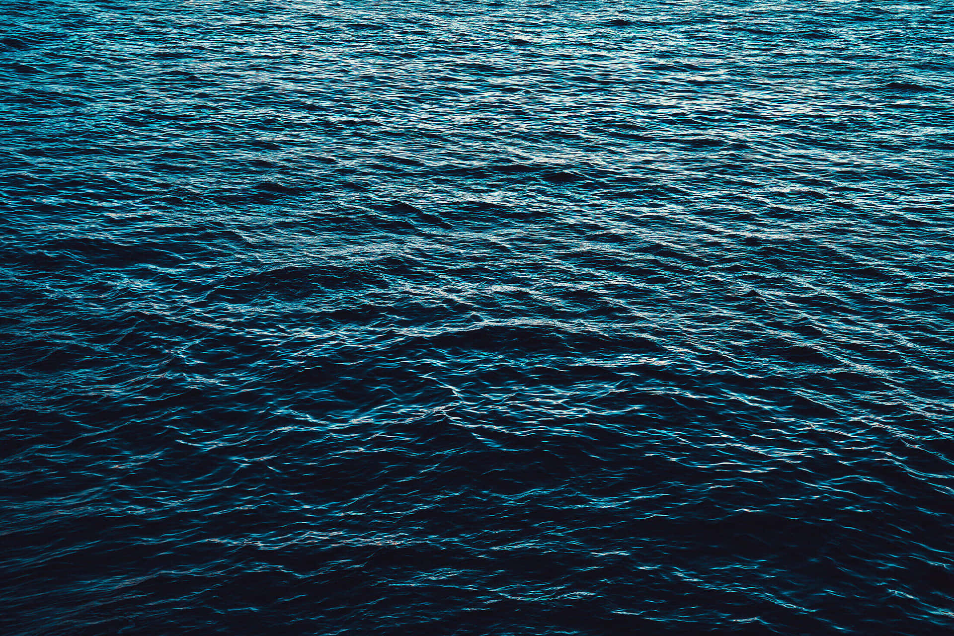深藍色海浪在昏暗光線下泛起漣漪