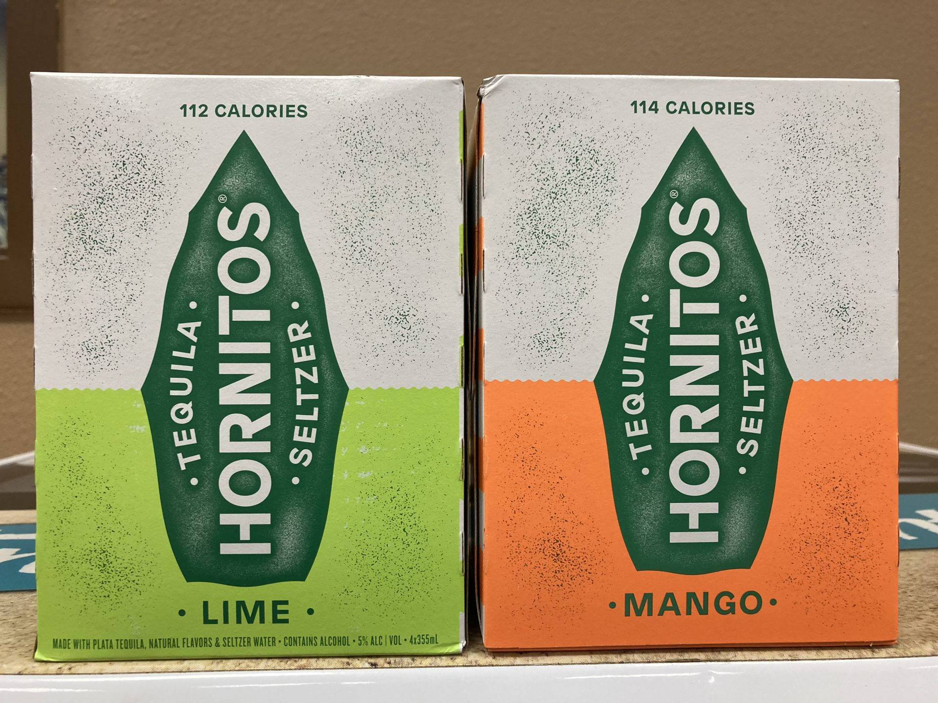 兩盒Hornitos龍舌蘭酒蘇打水青檸和芒果口味在枱面上。