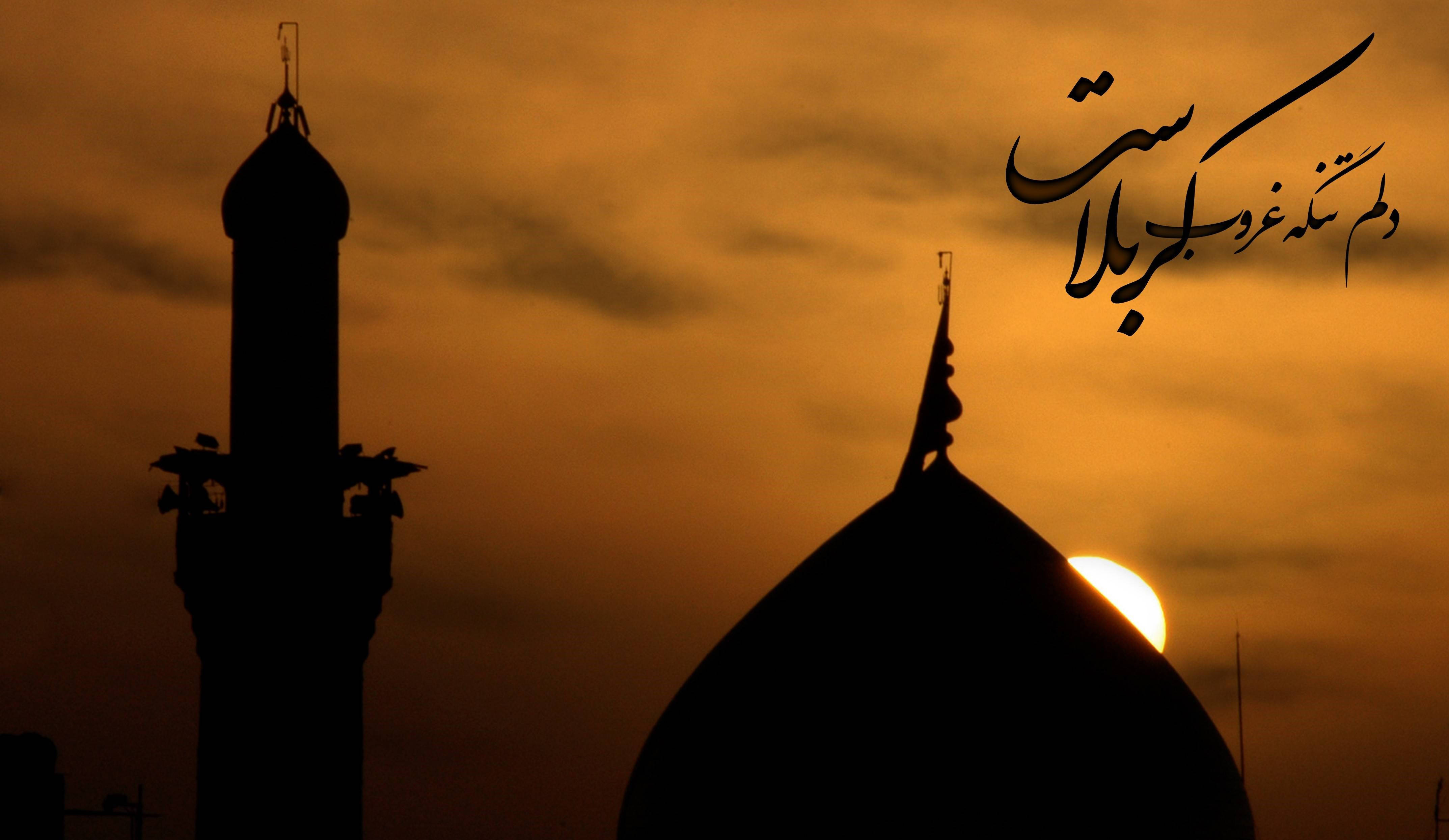 Karbala 桌布 壁紙 — 清真寺宣禮塔和圓頂的剪影，映襯著溫暖的橙色日落天空，上方漂浮著阿拉伯書法。